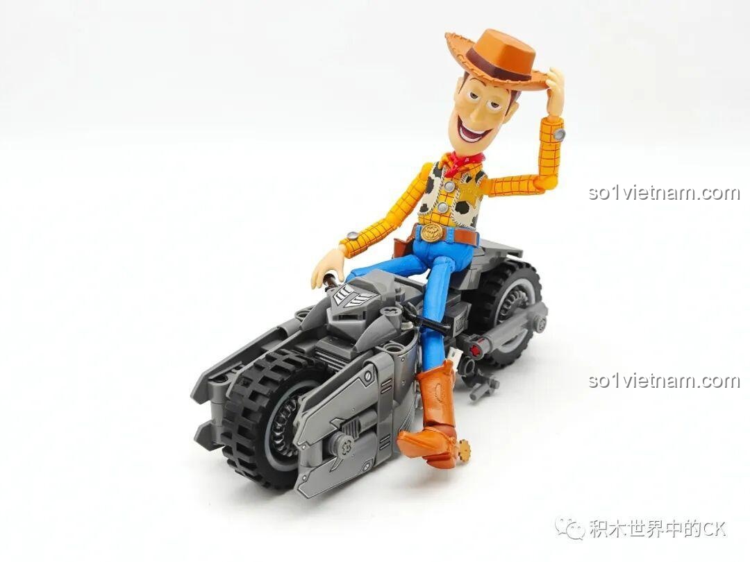 Mô hình JIESTAR 58051 Xe mô tô của Batman được đặt cùng nhân vật Woody, thể hiện khả năng kết hợp vui chơi sáng tạo.