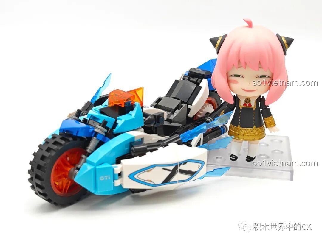 Mô hình xe máy Moto Cyberangel JIESTAR 58052 được đặt cạnh mô hình nhân vật Anya Forger để so sánh kích thước.