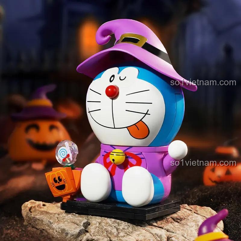 Mô hình Doraemon: Halloween K20419 của Keeppley được lắp ráp hoàn chỉnh, đội mũ phù thủy, cầm kẹo, bên cạnh là bí ngô