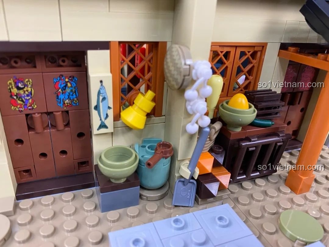 Khu vực sân sau với các chi tiết như chum nước, nông cụ và rau củ.