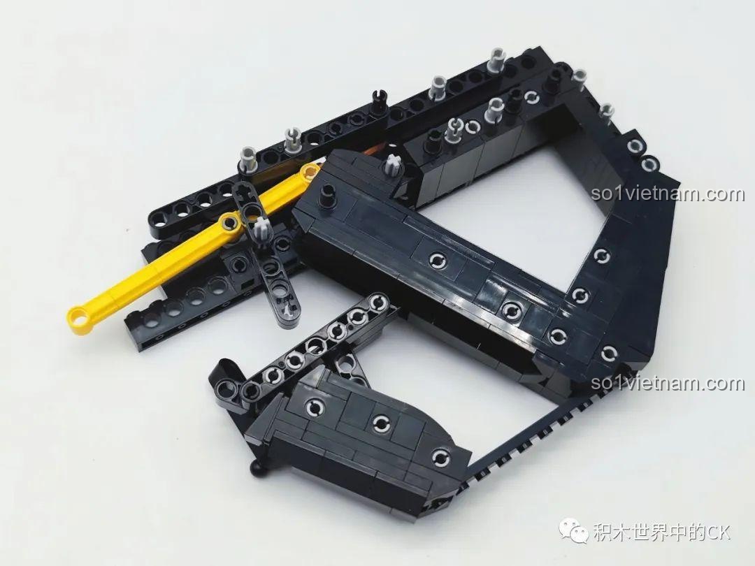 Lắp ráp phần báng súng của mô hình JIESTAR 58023, sử dụng nhiều thanh technic để tạo sự chắc chắn và hình dáng đặc trưng.