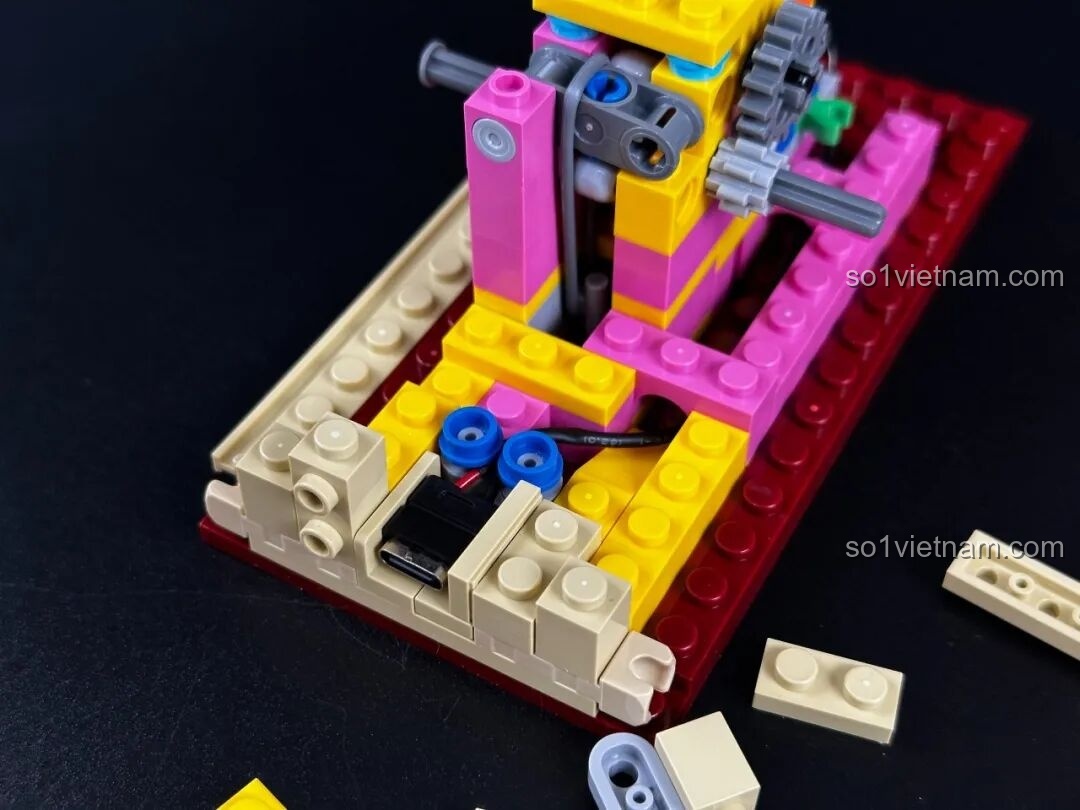 Quá trình lắp ráp cơ cấu cuộn phim của bộ Pantasy Máy Chiếu Phim Cổ Điển Retro 85010, với các bánh xe và dây đai, tạo nên hệ thống chuyển động của phim.