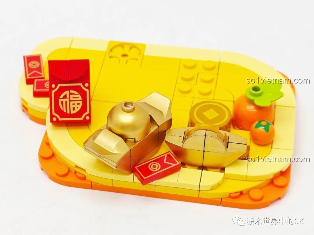 Quá trình lắp ráp phần đế của mô hình Rồng Xanh Tụ Bảo với các thỏi vàng và bao lì xì.