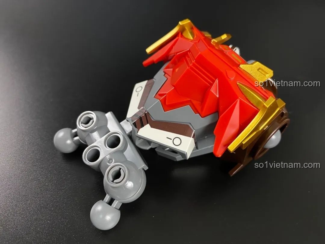 Lắp ráp phần giáp vai màu đỏ và vàng kim cho mô hình Tôn Ngộ Không, các lớp giáp được xếp chồng lên nhau.