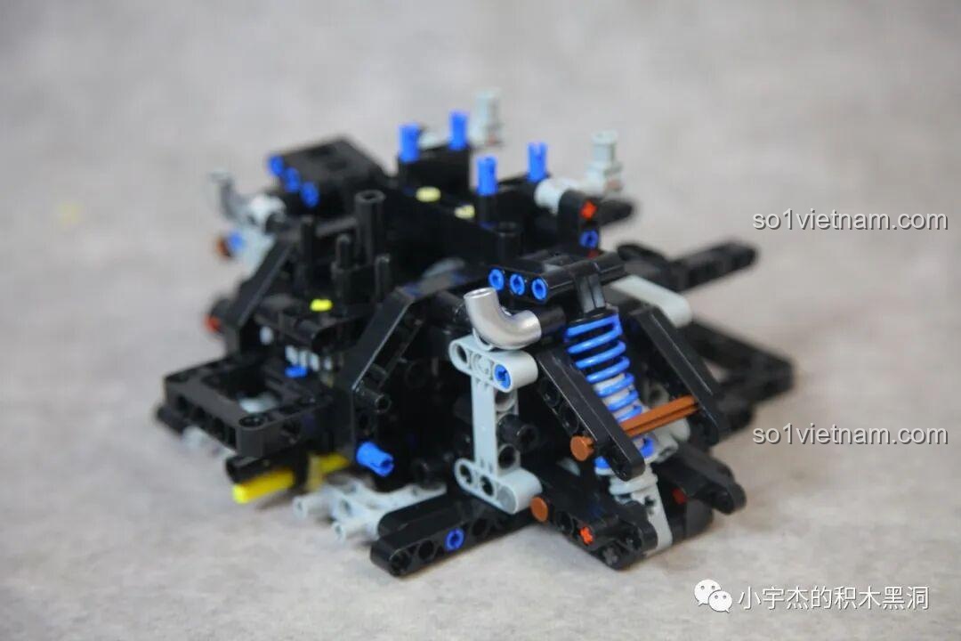 Quá trình lắp ráp hệ thống treo sau của mô hình CBOX X001 Ferrari F40 với các chi tiết Technic phức tạp và lò xo giảm xóc màu xanh.