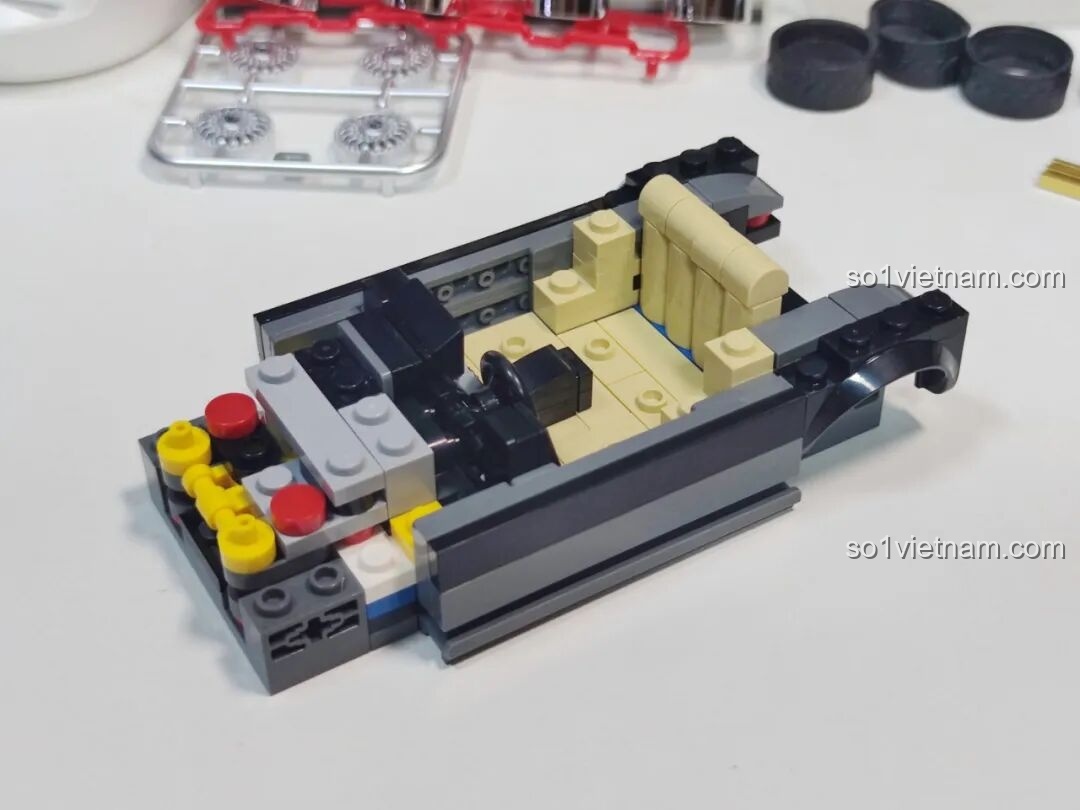 Giai đoạn lắp ráp phần khung gầm và nội thất bên trong của xe Pinbo PB8827 với ghế ngồi và vô lăng.