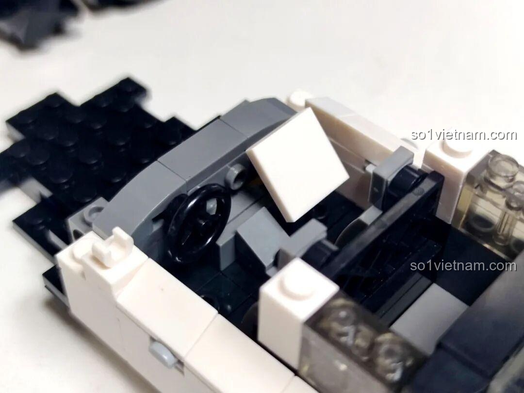 Cận cảnh quá trình lắp ráp phần nội thất của xe cảnh sát Reobrix 816, với chi tiết vô lăng và ghế ngồi.