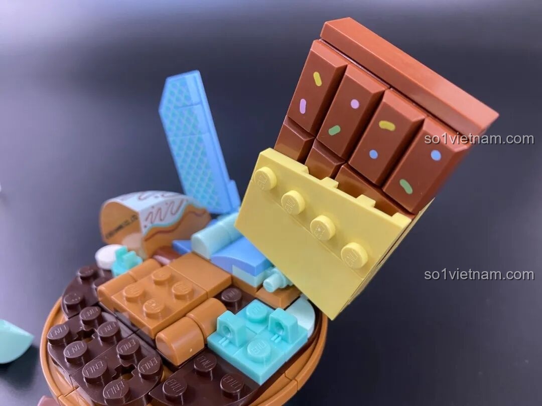 Quá trình lắp ráp phần bánh sô-cô-la của cupcake Pochacco, sử dụng các mảnh ghép màu nâu hấp dẫn.