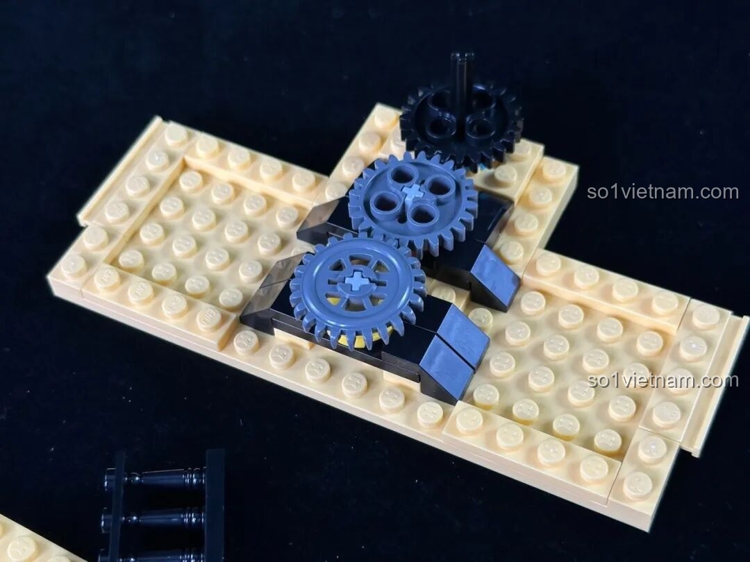 Sân khấu phụ với minifigure ảo thuật gia trong chiếc hộp đỏ, bên cạnh là chú chim bồ câu và lá bài.