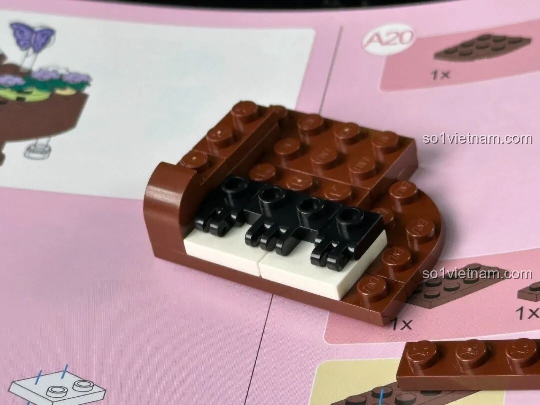 Sân khấu phụ với minifigure nghệ sĩ piano và cây đàn grand piano màu nâu, trang trí bằng hoa và bướm.