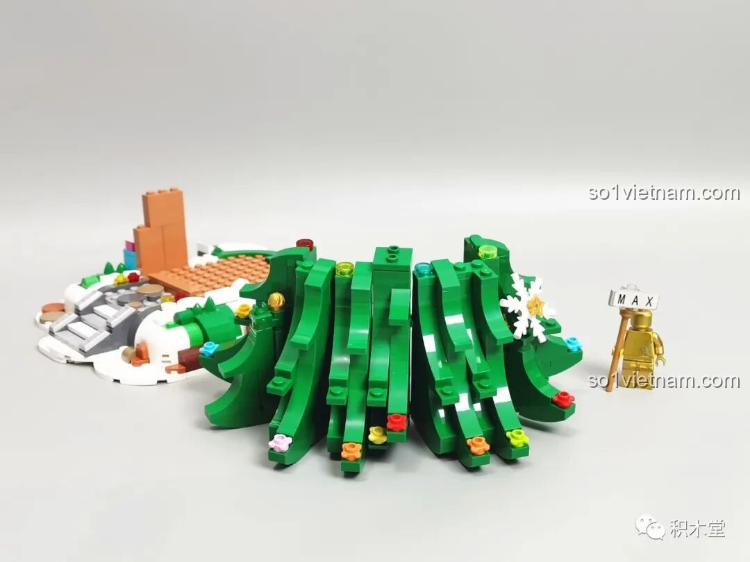 Lắp ráp phần thân cây thông bằng các mảnh ghép màu xanh và khớp nối, tạo hình cong tự nhiên.