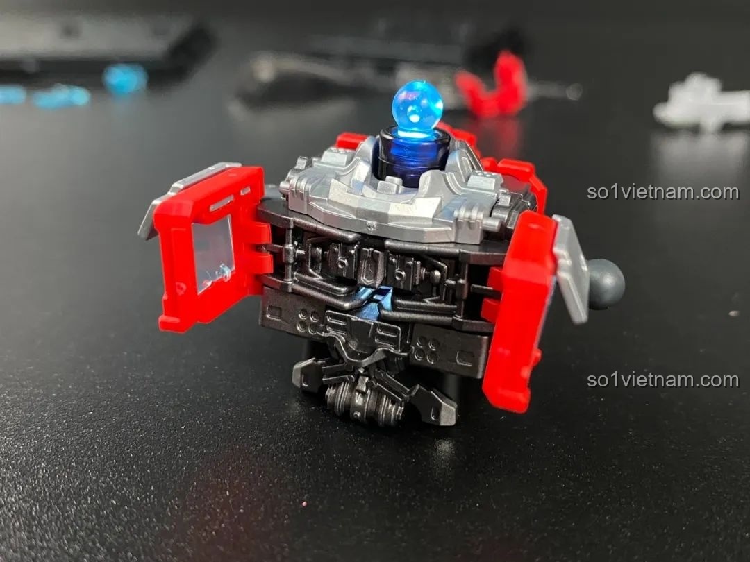 Phần thân của Optimus Prime đang được lắp ráp, với cụm đèn LED ở trung tâm phát ra ánh sáng xanh.