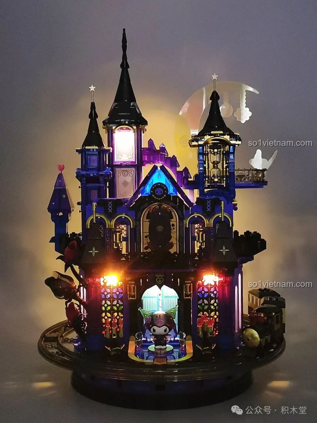 Lâu đài Kuromi rực rỡ dưới ánh sáng vàng ấm áp từ đèn LED, chiếu sáng các ô cửa sổ kính màu.