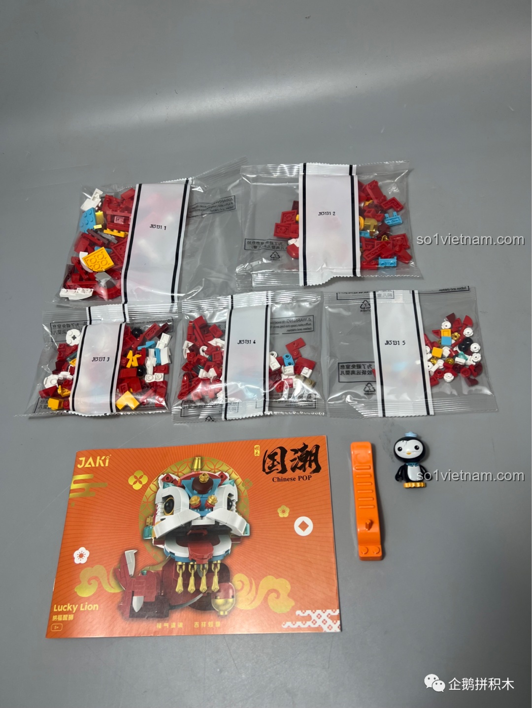 Các túi mảnh ghép và sách hướng dẫn của bộ đồ chơi lắp ráp JAKI Sư Tử Thức Tỉnh Ban Phúc, cho thấy sự chuẩn bị kỹ lưỡng trước khi bắt đầu lắp ráp.