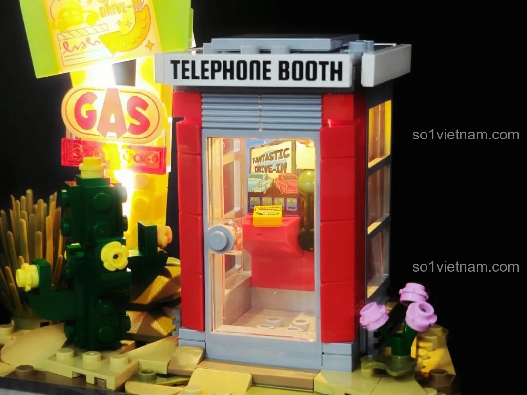 Cận cảnh hơn các chi tiết bên trong bốt điện thoại của bộ Lumibricks L9082 Trạm Dừng Chân Hoàng Hôn, bao gồm poster và sách.