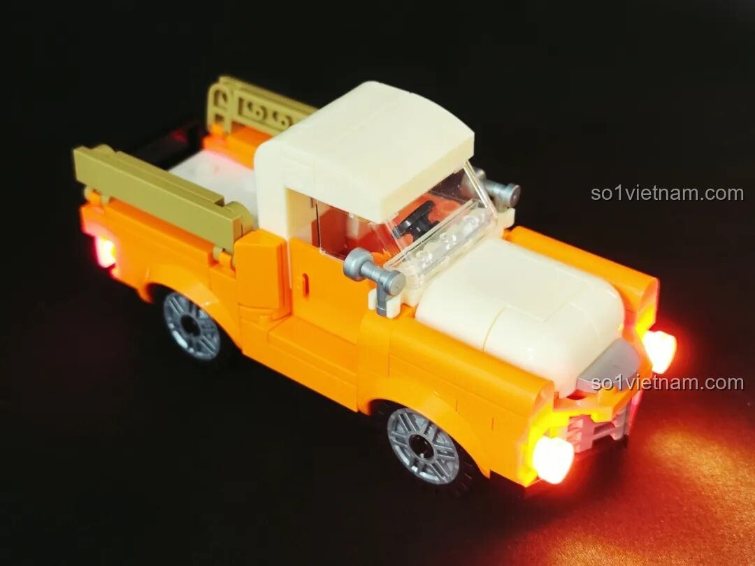 Mô hình Trạm Dừng Chân Hoàng Hôn Lumibricks L9082 với biển hiệu và bốt điện thoại sáng rực trong đêm.
