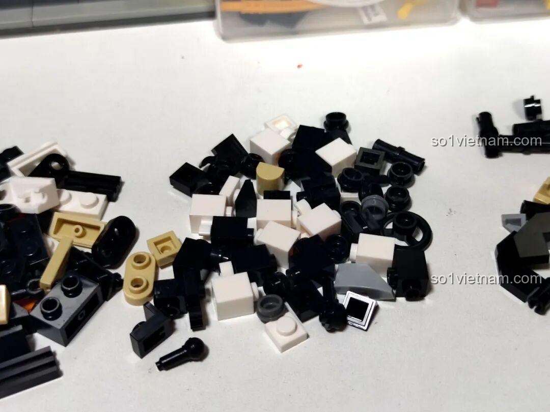 Các mảnh ghép màu trắng và đen của bộ Xbert 66011 MB RACER 4X4 được đổ ra bàn, cho thấy chất liệu nhựa ABS cao cấp.