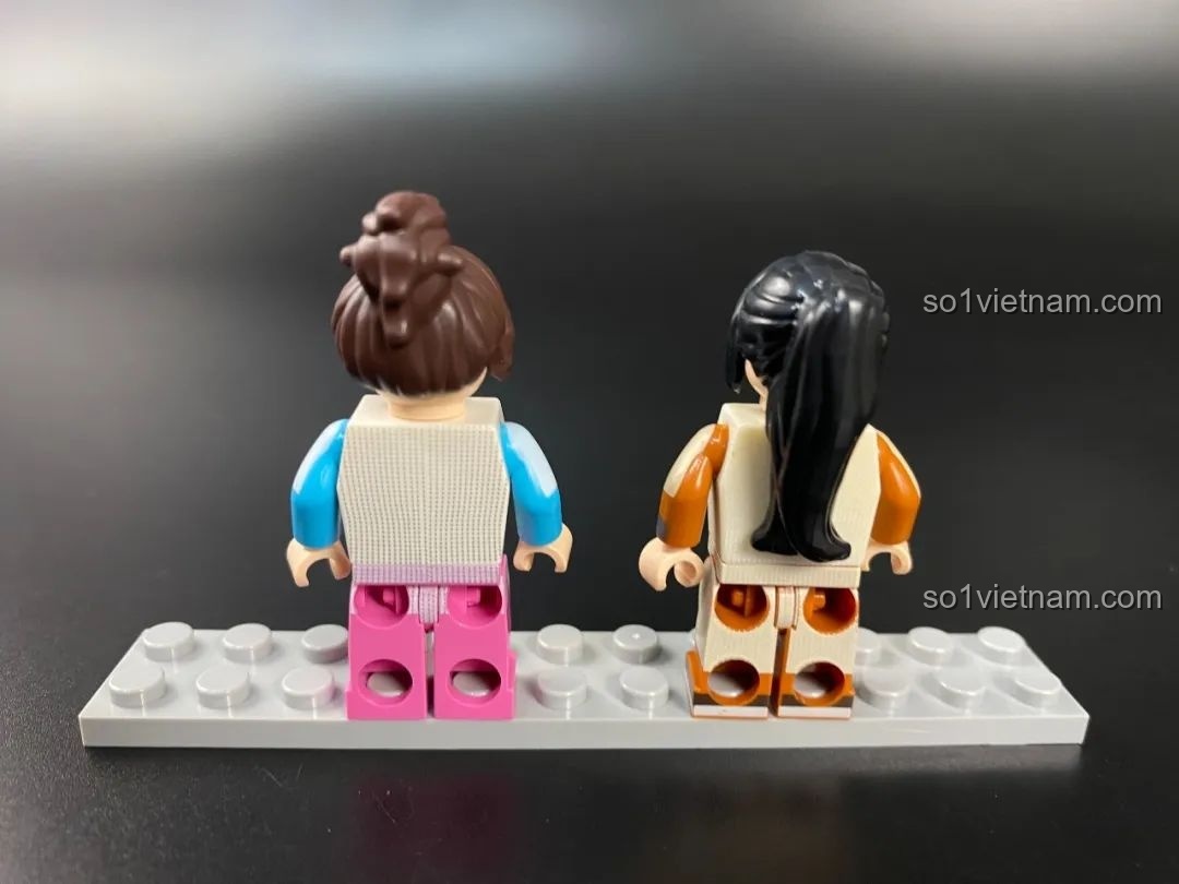 Mặt sau của hai minifigures nữ, thể hiện chi tiết in trên lưng áo.