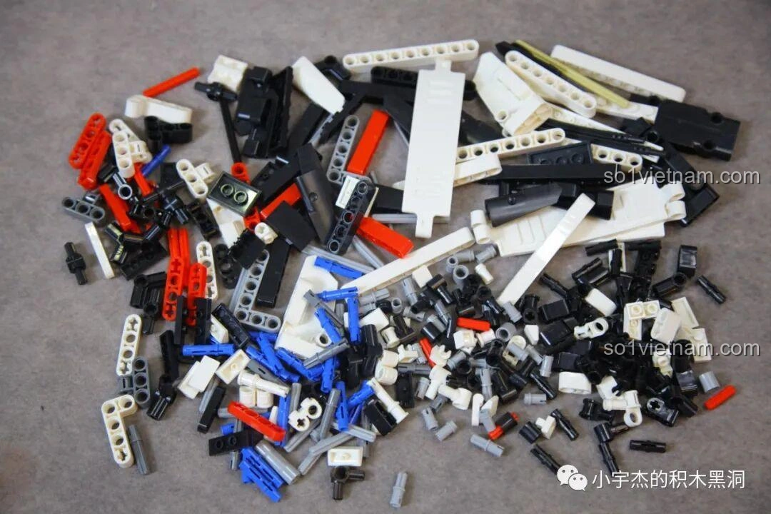 Toàn bộ các mảnh ghép từ gói số 3 của bộ lắp ráp Mei Ji 8622A Nissan GT-R được đổ ra, bao gồm nhiều chi tiết màu đen, trắng, đỏ, xanh.