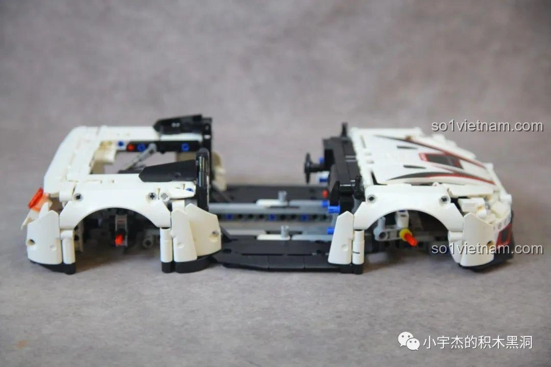 Khung xe của mô hình Mei Ji 8622A Nissan GT-R đang được nối lại, cho thấy cấu trúc kỹ thuật bên trong và sự liên kết giữa các phần.