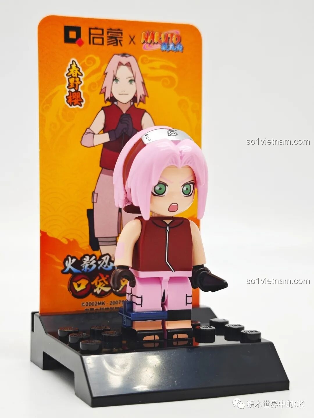 Minifigure Haruno Sakura đứng trên đế trưng bày cùng thẻ bài, một phần của bộ sưu tập nhân vật Naruto Qman đáng tiền.