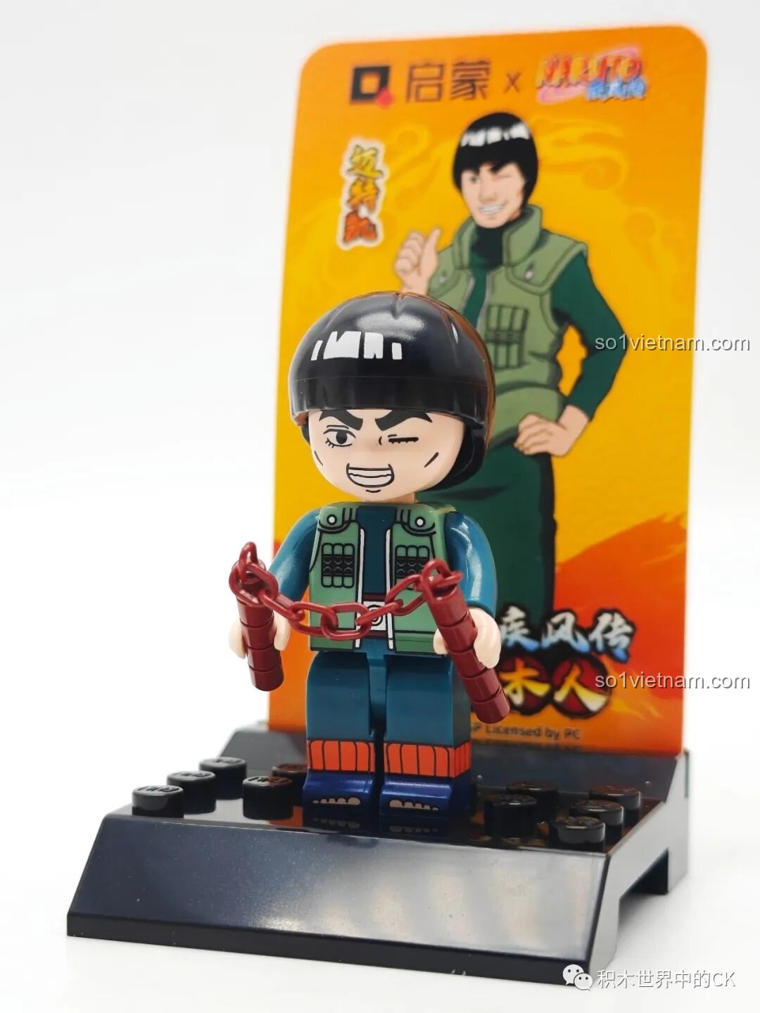 Minifigure Might Guy cầm côn nhị khúc đứng trên đế trưng bày, một phần của bộ sưu tập nhân vật Naruto Qman đáng tiền.