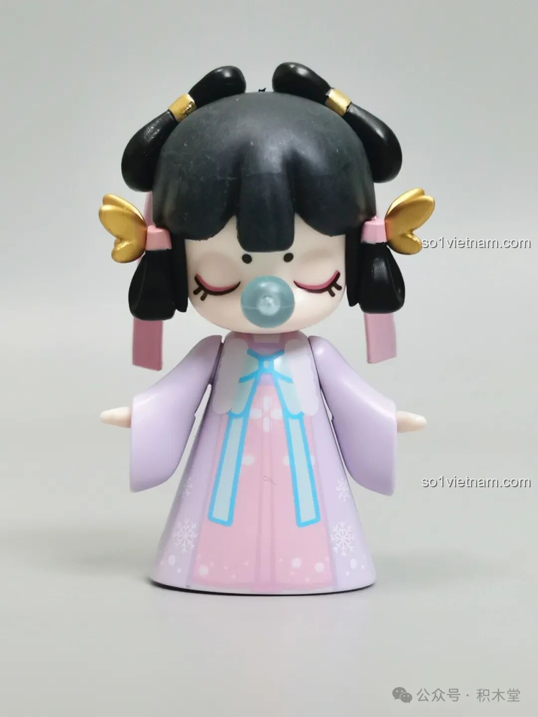 Cận cảnh minifigure cô bé Nanci Mùa Đông với trang phục màu tím và kiểu tóc cài nơ.