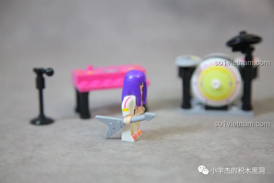 Minifigure nữ rocker của Sembo 714508 cầm cây đàn guitar điện màu bạc.