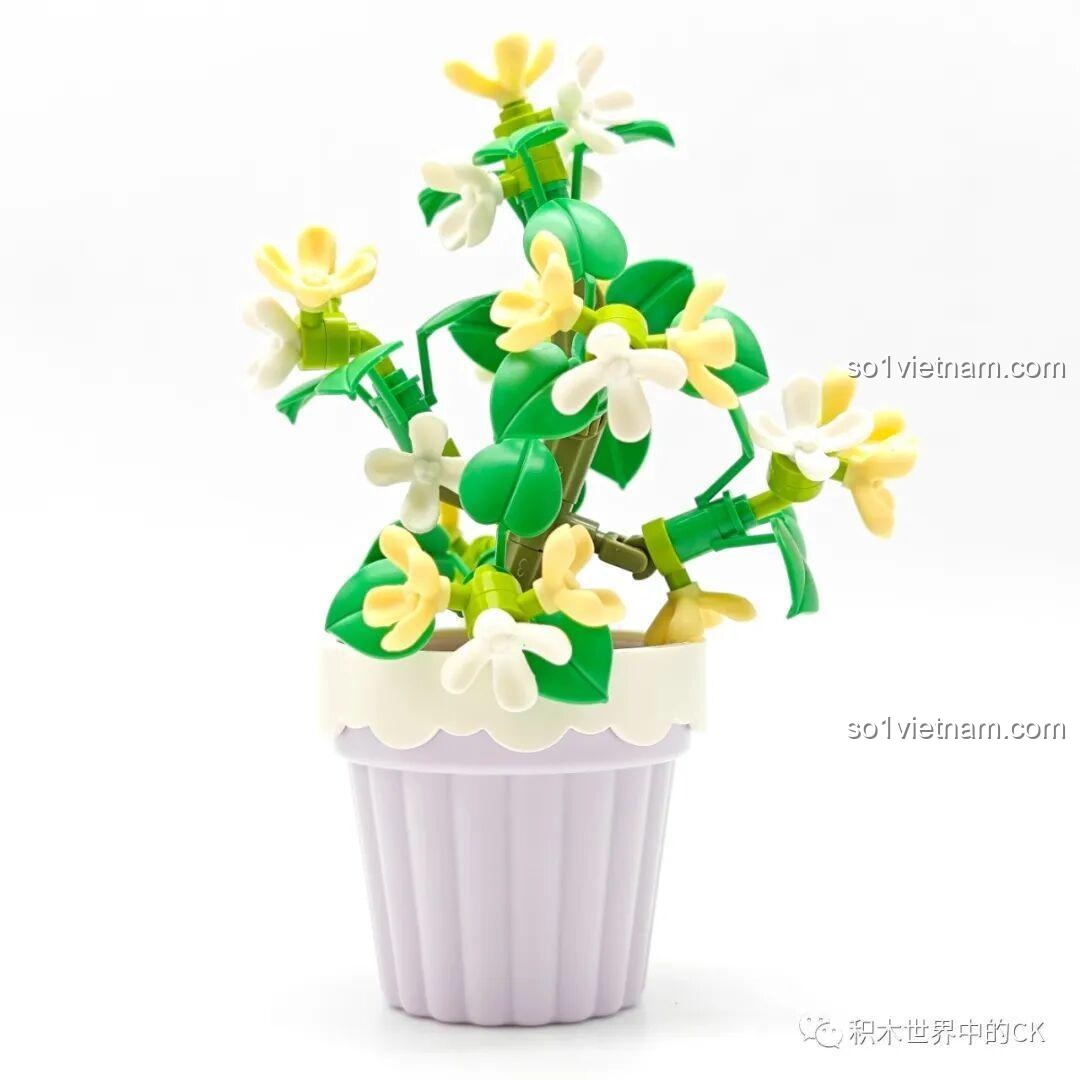 Mô hình chậu hoa mộc quế Sembo 611063 đã hoàn thành, có những bông hoa trắng và vàng nhỏ xinh trong chậu màu tím nhạt.