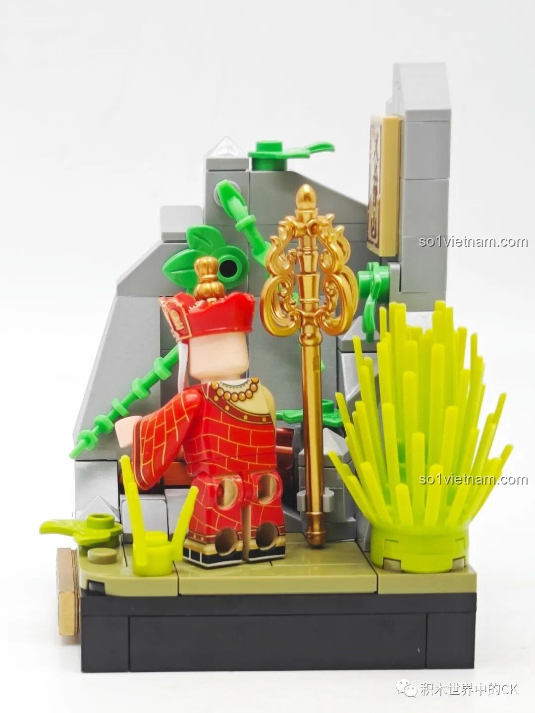 Góc nhìn chéo từ phía sau của mô hình Ngũ Hành Sơn, làm nổi bật Đường Tăng và cây tích trượng.