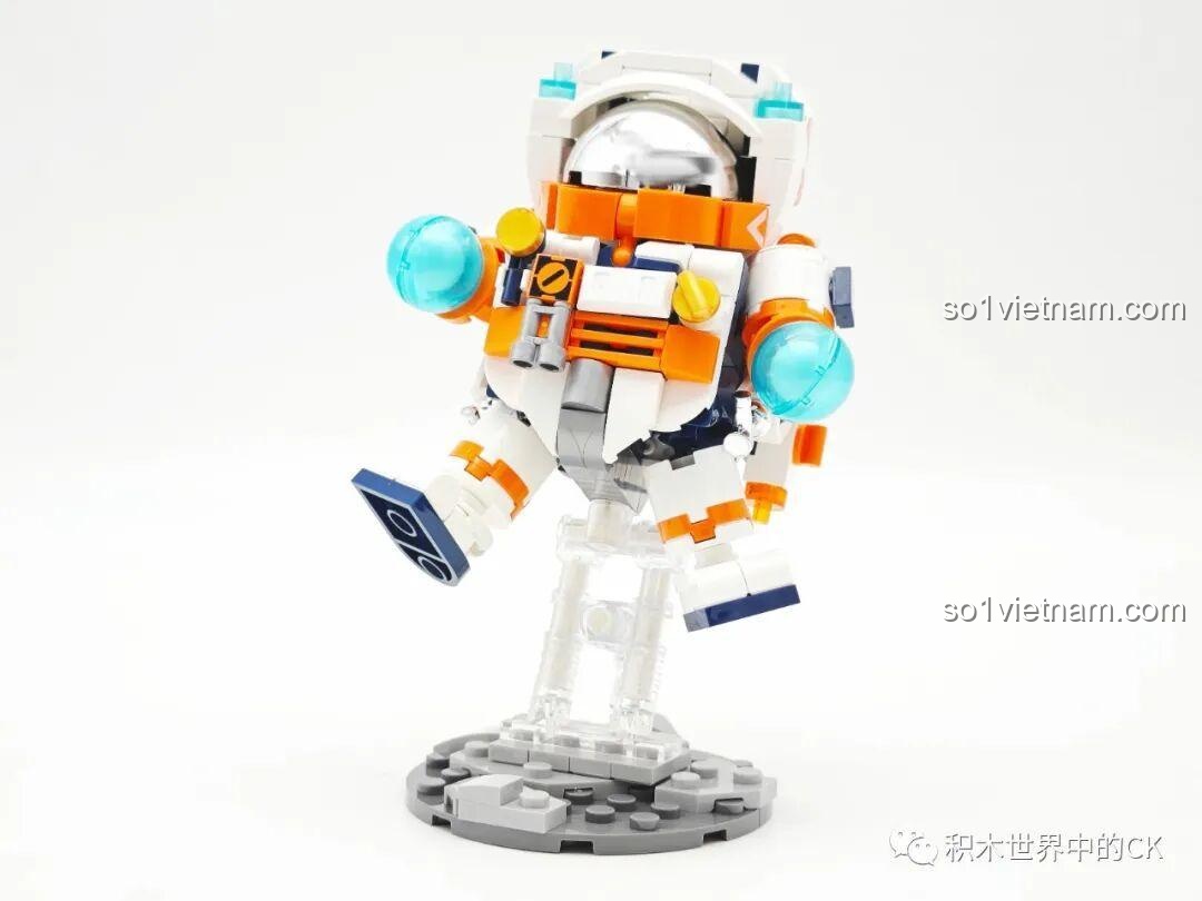 Mô hình Đồ chơi phi hành gia JAKI JK8505 đã hoàn thiện, tạo dáng đang bay trên đế trưng bày trong suốt.