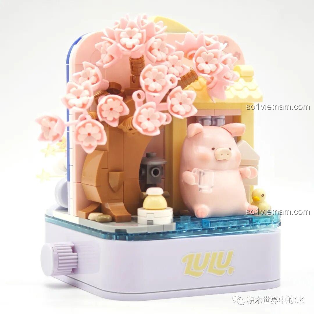 Mặt sau của mô hình Sembo 608077 với Lợn LuLu ngồi dưới gốc cây hoa anh đào.