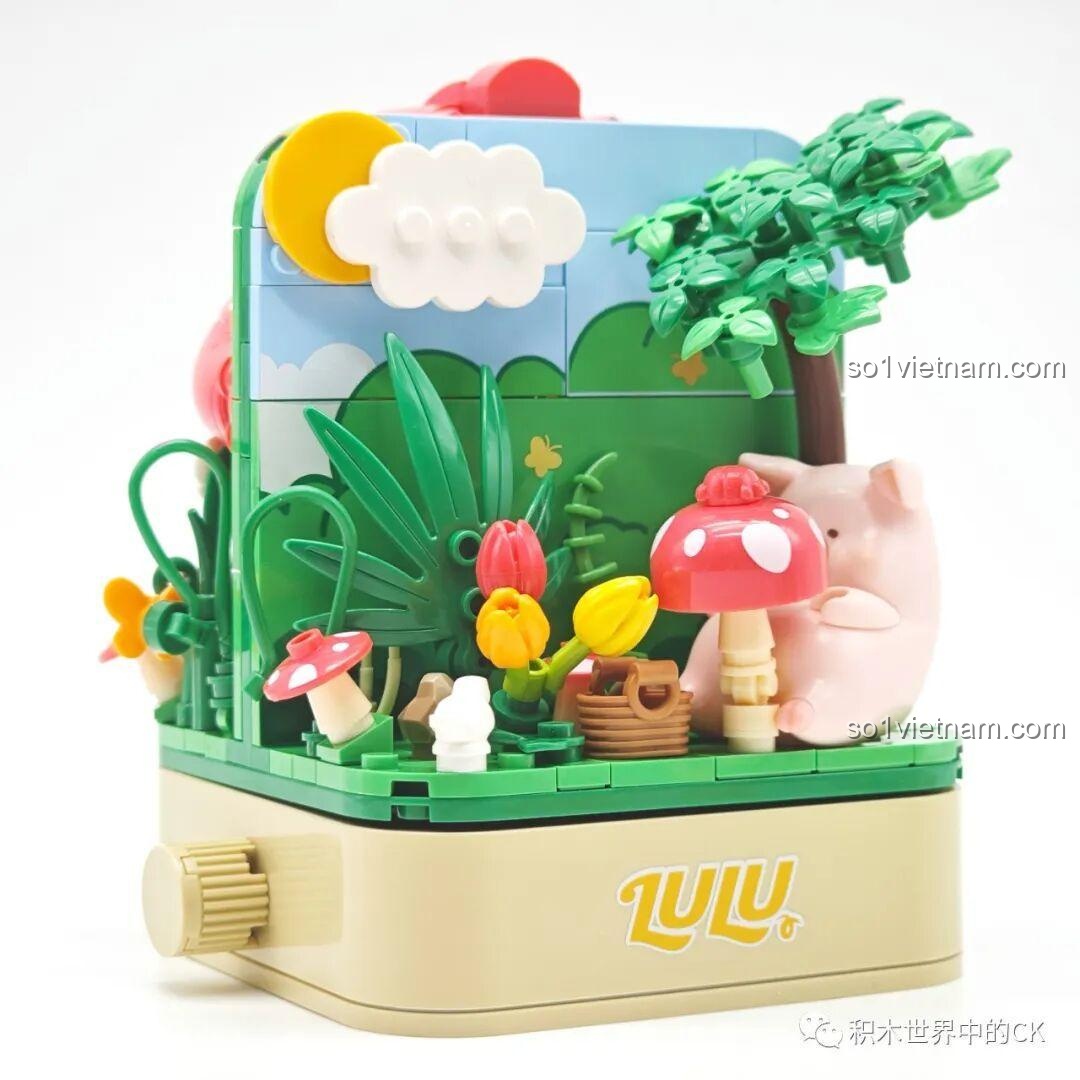 Mặt sau của mô hình Sembo 608076 với Lợn LuLu ngồi hái nấm trong khu vườn xanh mát.