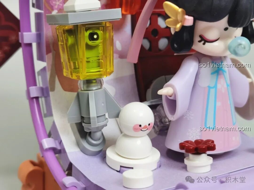 So sánh mô hình TOP TOY Nanci Cuộn Tranh mùa Đông hoàn thiện với hình ảnh trên hộp sản phẩm.