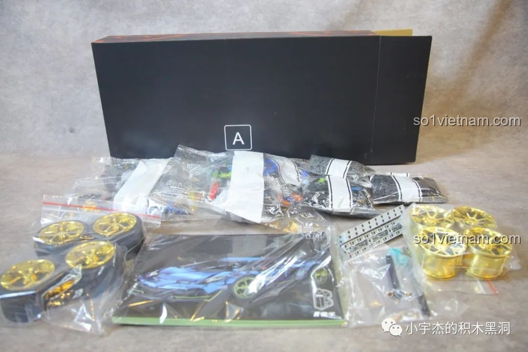 Mở hộp A của bộ K-box 10520, để lộ các túi chi tiết, sách hướng dẫn và hai bộ mâm xe mạ vàng.