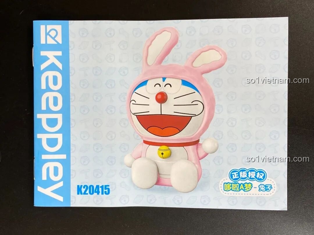 Mở hộp bộ lắp ráp Doraemon thỏ hồng, bên trong là các mảnh ghép lớn được đúc sẵn và sách hướng dẫn.