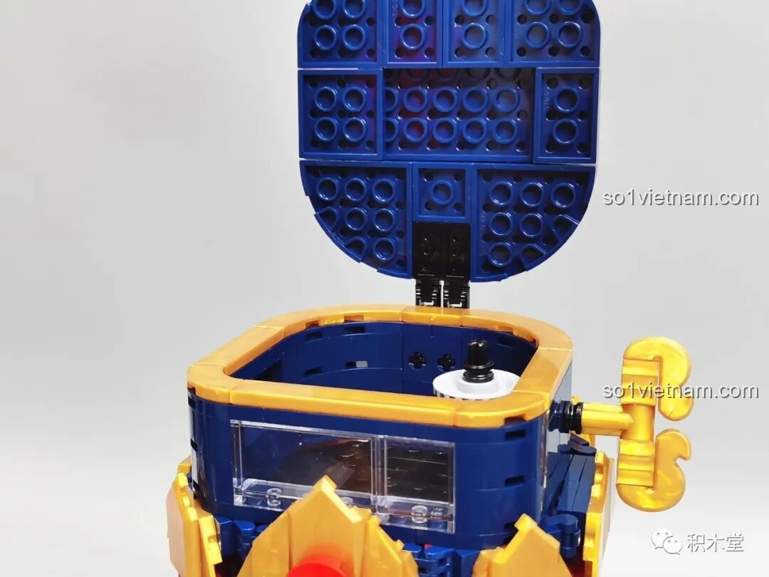 Mở nắp mũ của Hoàng Tử Kẹp Hạt Dẻ, để lộ không gian bên trong để chứa các viên bi giấy.