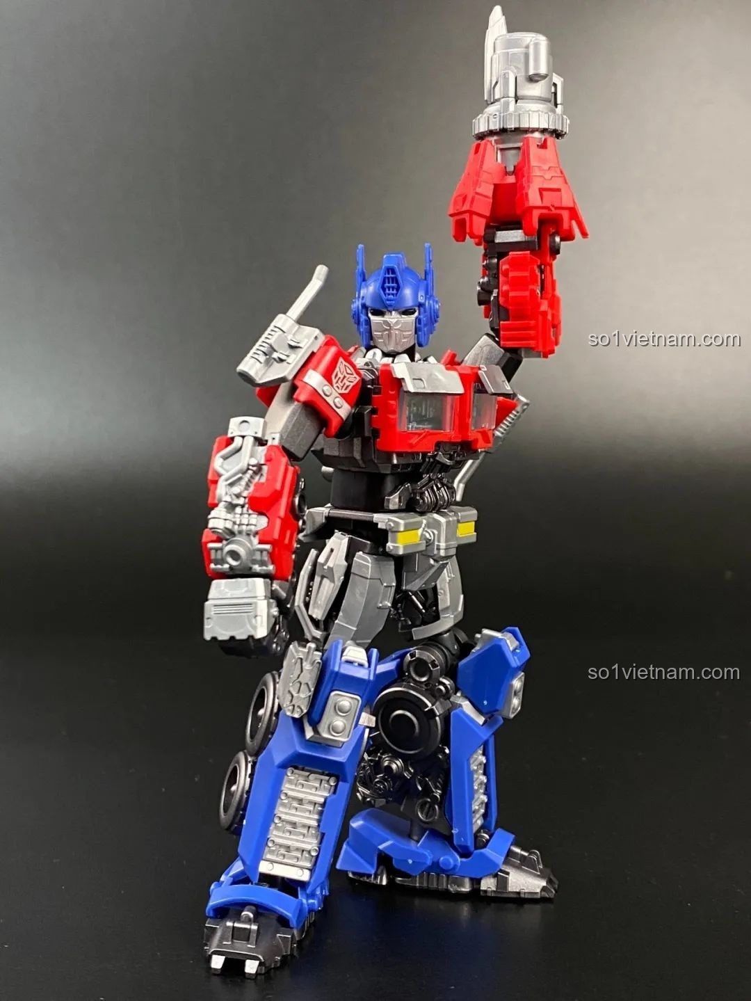 Mô hình Optimus Prime Blokees trong tư thế cầm súng blaster giơ lên cao, thể hiện sự mạnh mẽ và sẵn sàng chiến đấu.