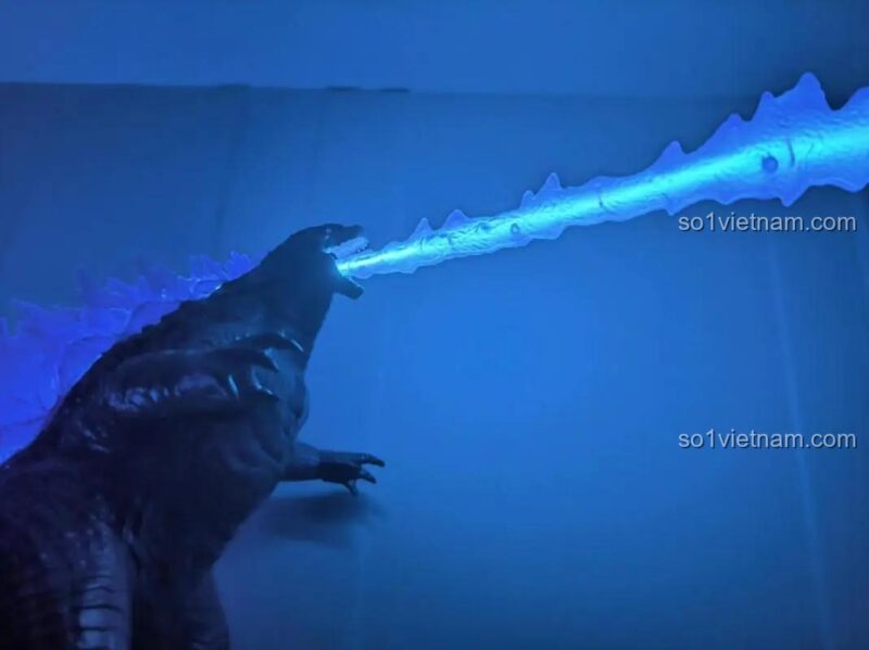 Ảnh review từ người dùng về bộ lắp ghép Godzilla, khoe hiệu ứng đèn LED xanh dương nổi bật trên vây lưng trong bóng tối.