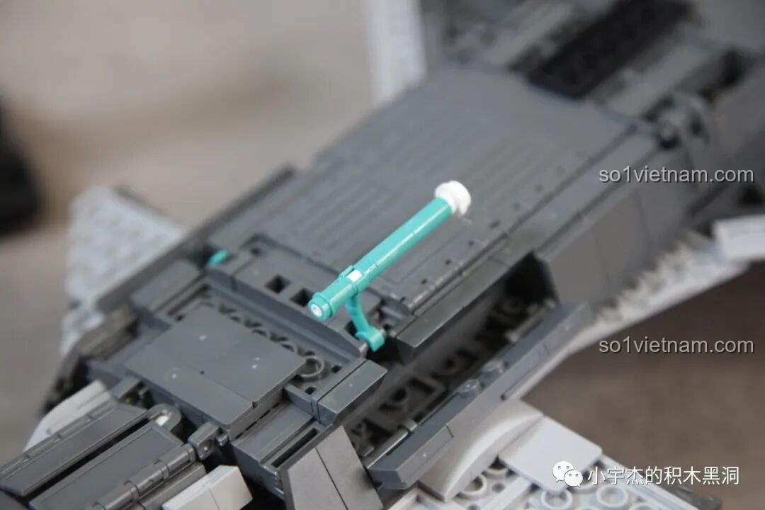 Minifigure phi công của Sluban J-20 M38-B1187 Tiêm Kích Tàng Hình đứng cạnh đế trưng bày, sẵn sàng cho nhiệm vụ.