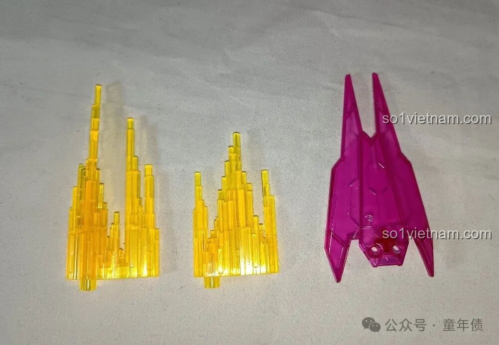 Các phụ kiện hiệu ứng năng lượng bằng nhựa trong suốt màu vàng và hồng, đi kèm trong bộ mô hình Sentinel Prime.