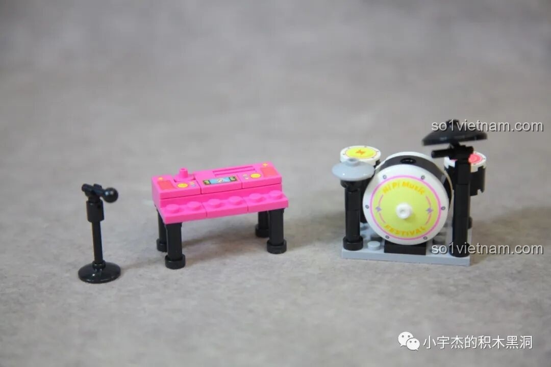 Các nhạc cụ mini trong bộ Sembo 714508, bao gồm dàn trống, đàn organ màu hồng và micro.