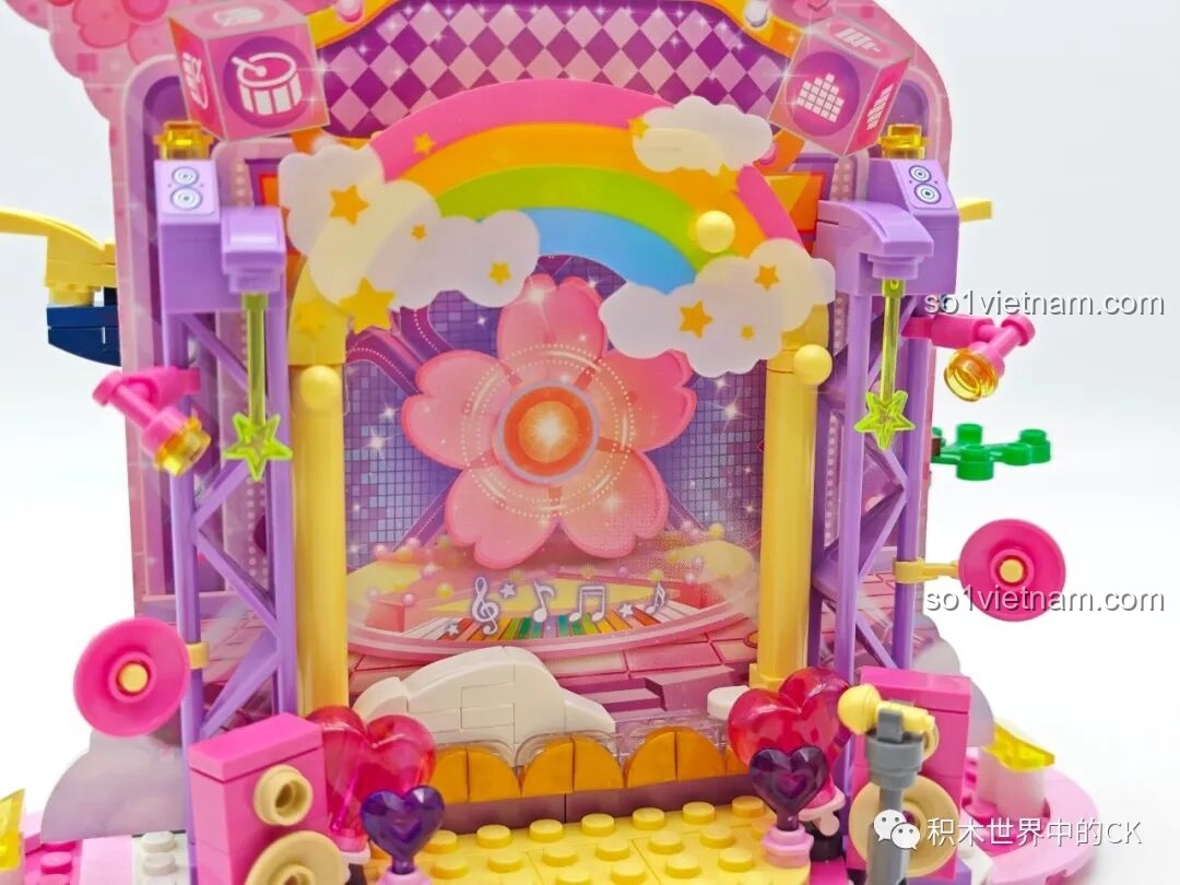 Cận cảnh phông nền sân khấu với cầu vồng và hoa trang trí của bộ QMAN 72033.