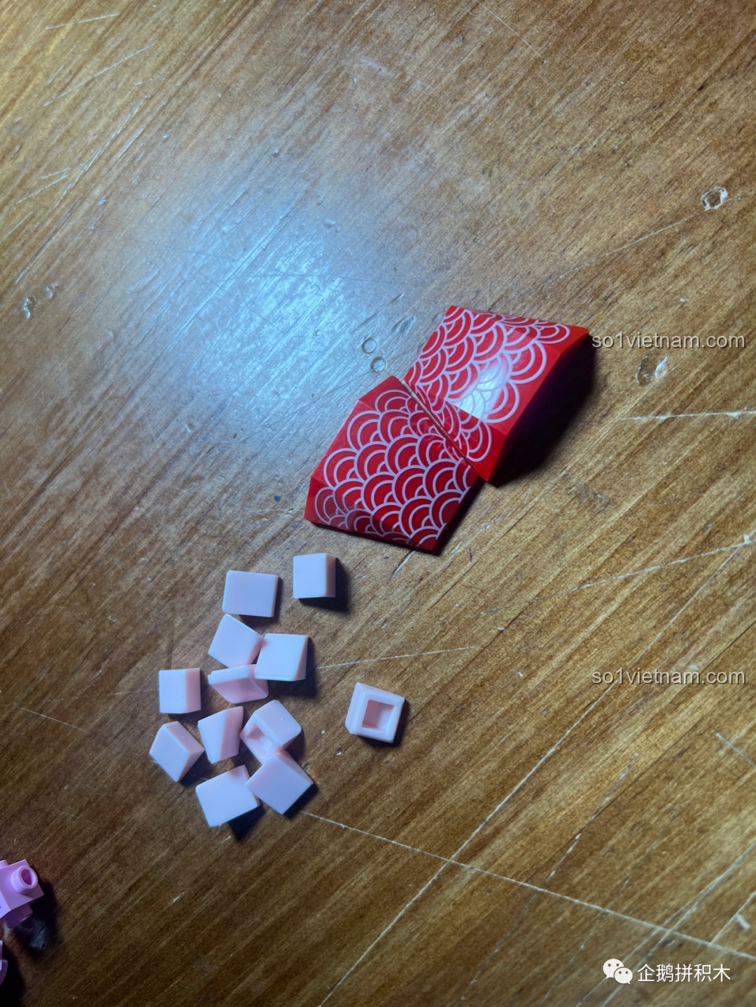 Cận cảnh quá trình lắp ráp Cá Chép May Mắn trên tay, cho thấy sự phức tạp và tỉ mỉ của các chi tiết, đặc biệt là phần đầu và thân cá.