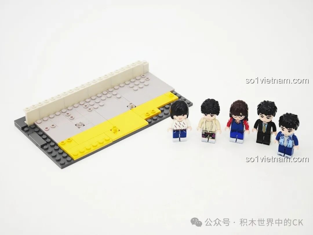 Quá trình lắp ráp phần nền móng của mô hình nhà Deok-sun với các minifigures của gia đình Sung đứng bên cạnh.