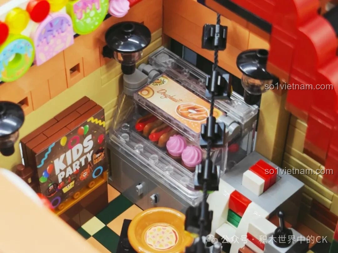 Chi tiết đồng hồ treo tường trong BAKA 33202 Xưởng Bánh Donut, với kim chỉ giờ và phút.