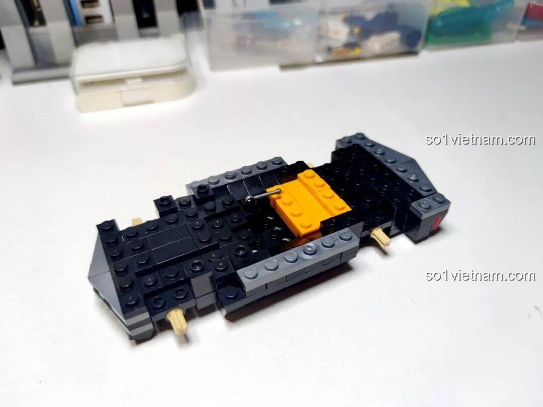 Khung xe ban đầu của bộ GAOMISI T1092 Xe Cadillac mui trần đang được lắp ráp, với các mảnh ghép màu đen và vàng.