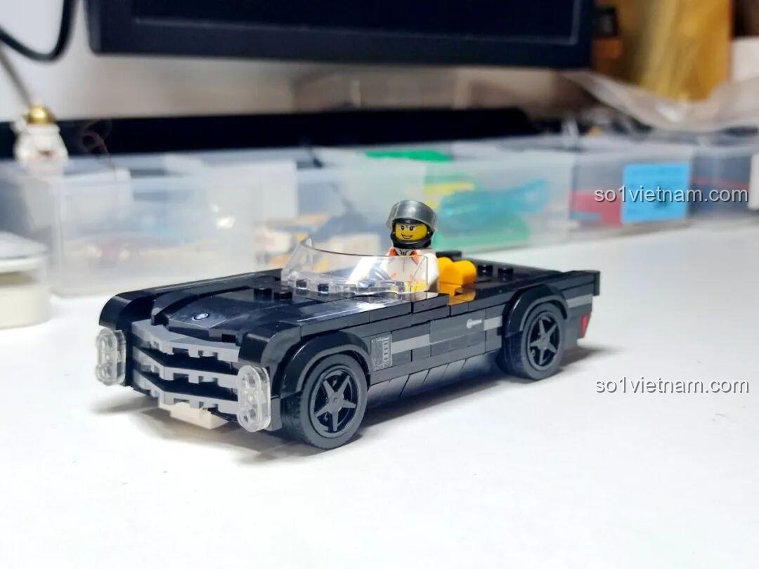 Minifigure tay đua ngồi trong Xe Thể Thao Mui Trần Cadillac Cổ Điển GAOMISI T1092, sẵn sàng cho cuộc đua.