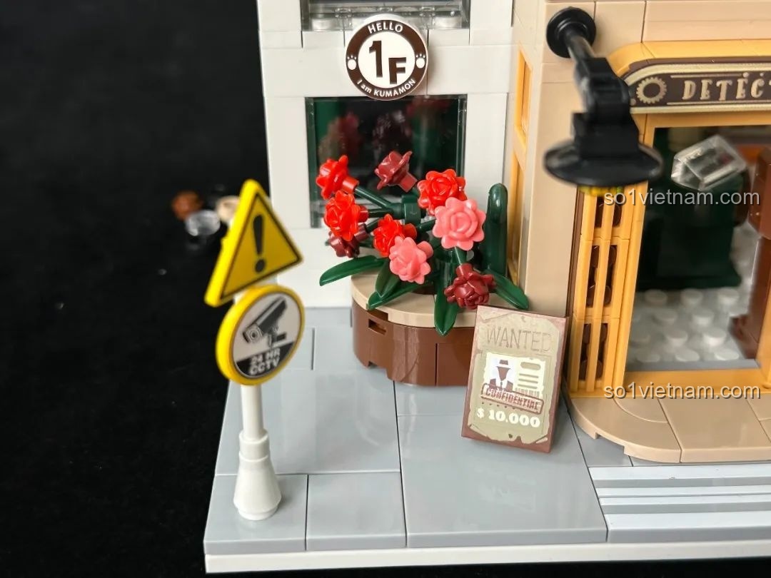 Các chi tiết ngoại thất tầng trệt của inbrixx 880035 Văn phòng Thám tử Kumamon bao gồm biển báo, chậu hoa và poster truy nã.