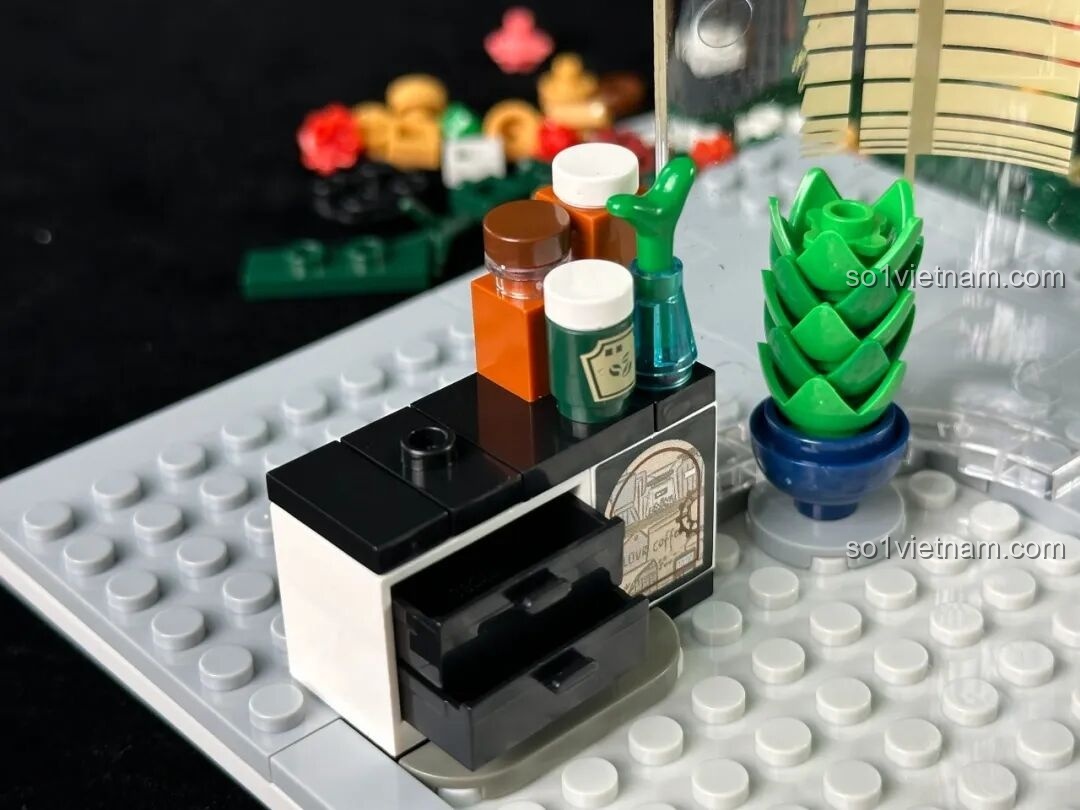 Chi tiết nội thất tầng trệt của inbrixx 880035 Văn phòng Thám tử Kumamon với chậu cây xanh và các lọ đựng đồ nhỏ xinh.